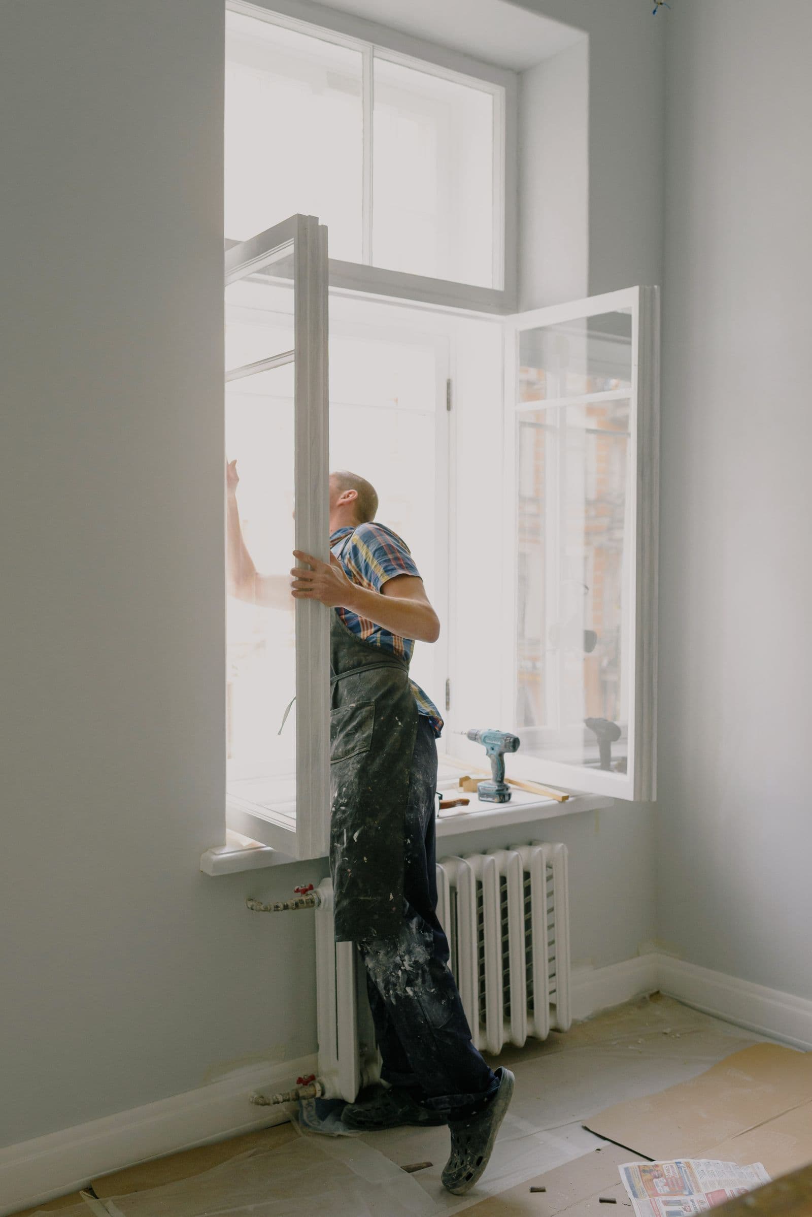 Factory-certified installer fitting a new replacement window in a Central Texas home